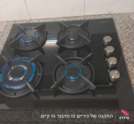 כיריים גז עם ארבעה מבערים וכפתורי שליטה